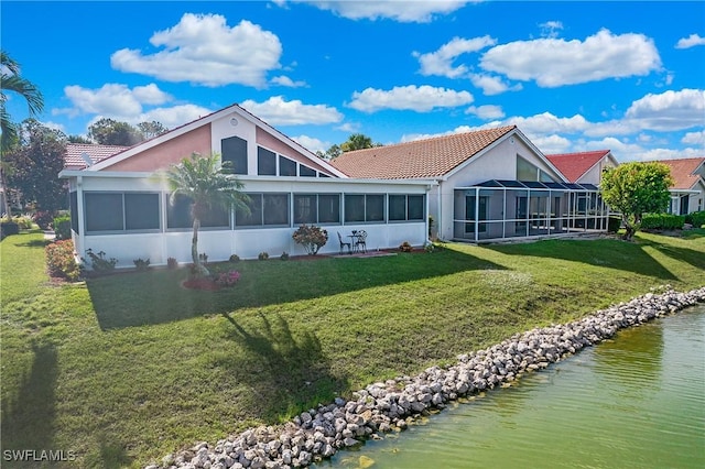 159 Lady Palm Dr, Naples, FL 34104 - back of property featuring a sunroom, a tiled roof, a lawn, stucco siding, and a water view