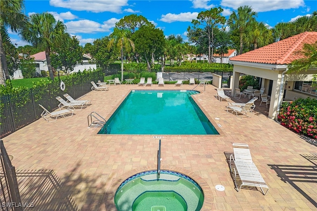 view of swimming pool with a patio and a hot tub