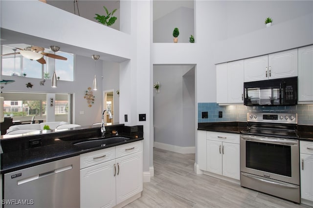 kitchen featuring appliances with stainless steel finishes, ceiling fan, sink, high vaulted ceiling, and white cabinets