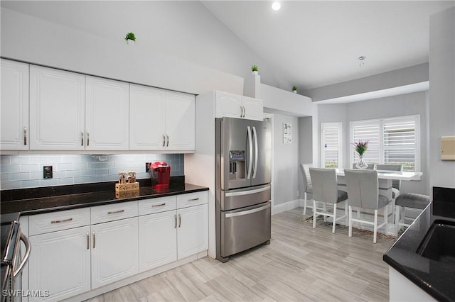 159 Lady Palm Dr, Naples, FL 34104 - kitchen with stainless steel refrigerator with ice dispenser, stove, white cabinets, tasteful backsplash, and high vaulted ceiling