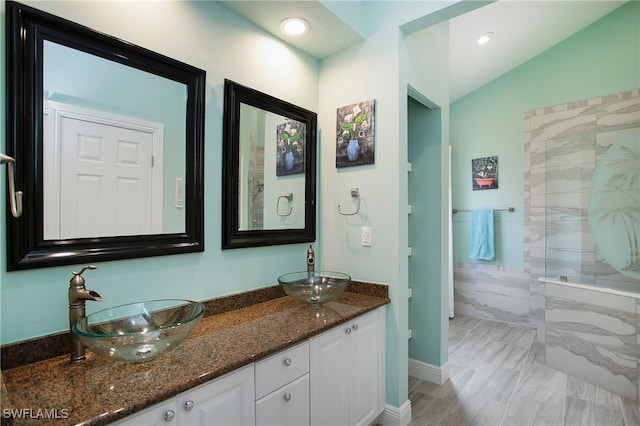 bathroom with vanity, a shower, and lofted ceiling