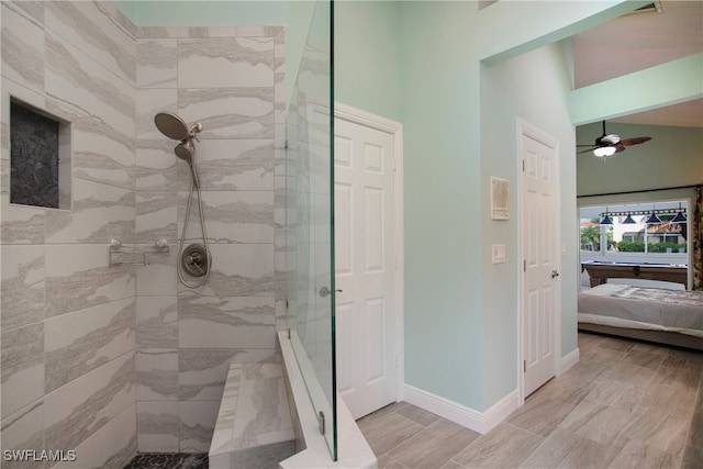 bathroom featuring a tile shower and ceiling fan