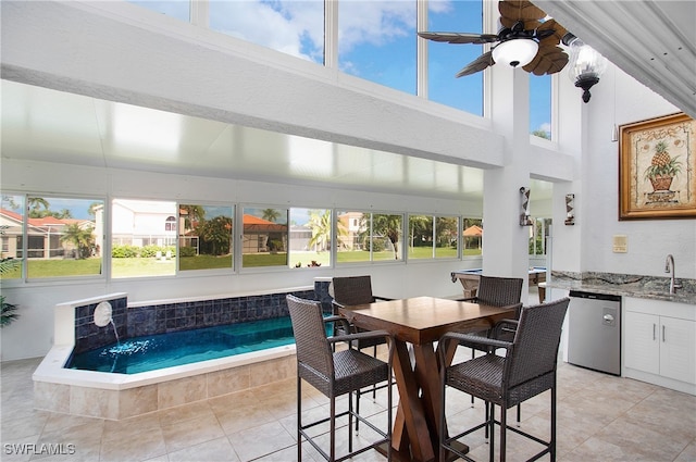 sunroom with ceiling fan, a wealth of natural light, and sink