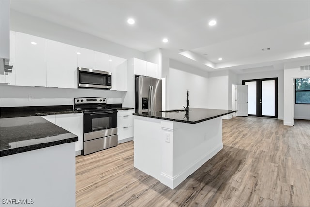 kitchen featuring a center island with sink, white cabinets, sink, light hardwood / wood-style flooring, and stainless steel appliances