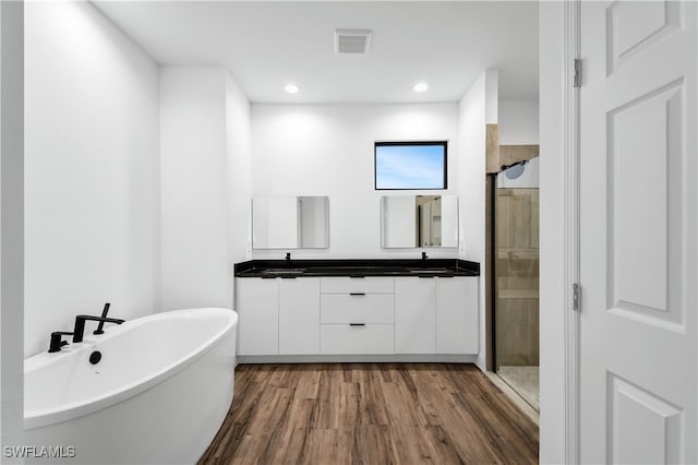 bathroom with independent shower and bath, vanity, and wood-type flooring