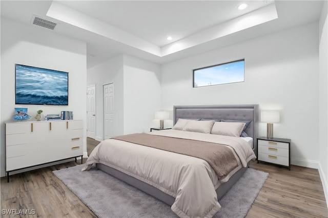 bedroom featuring hardwood / wood-style floors and a raised ceiling