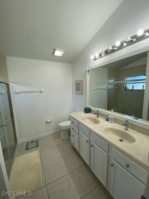 bathroom with tile patterned flooring, vanity, toilet, and walk in shower