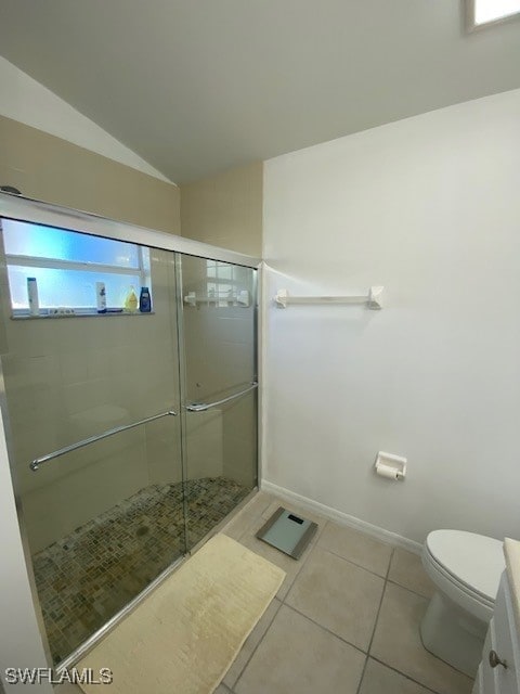 bathroom featuring tile patterned flooring, lofted ceiling, toilet, and a shower with shower door