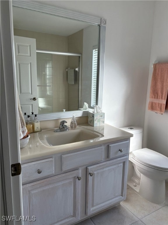 bathroom featuring toilet, tile patterned flooring, vanity, and walk in shower