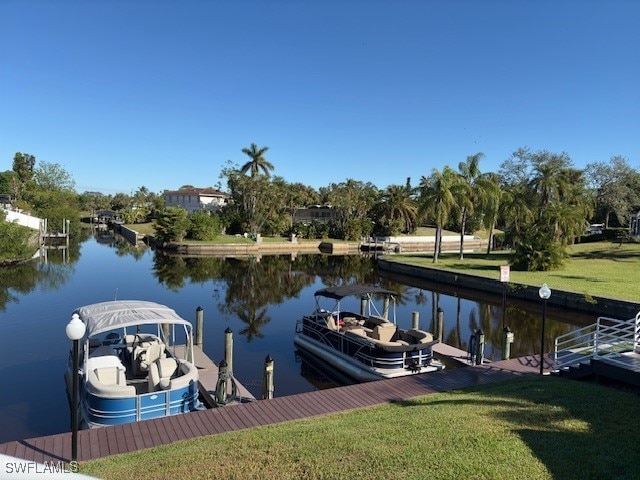 dock area featuring a water view and a yard