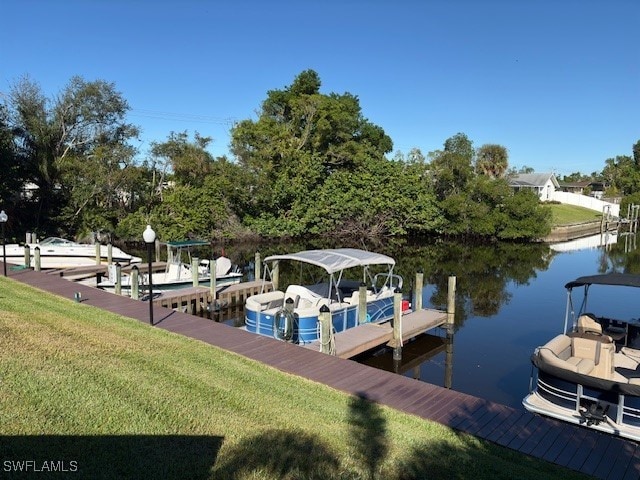 dock area with a water view and a yard