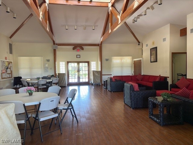 living room featuring beamed ceiling, track lighting, high vaulted ceiling, and dark wood-type flooring