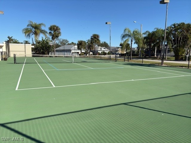 view of tennis court with basketball hoop