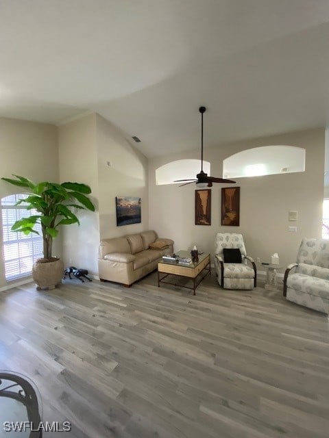 living room featuring hardwood / wood-style floors, ceiling fan, and lofted ceiling