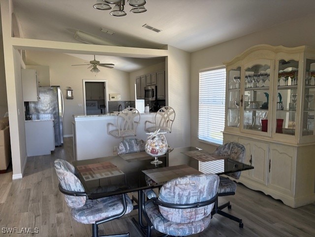 13358 Queen Palm Run, North Fort Myers, FL 33903 - dining space with visible vents, baseboards, a ceiling fan, wood finished floors, and vaulted ceiling