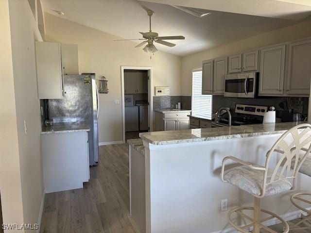 13358 Queen Palm Run, North Fort Myers, FL 33903 - kitchen with ceiling fan, a peninsula, appliances with stainless steel finishes, lofted ceiling, and washer and clothes dryer