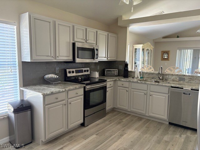 13358 Queen Palm Run, North Fort Myers, FL 33903 - kitchen featuring decorative backsplash, white cabinetry, a sink, and appliances with stainless steel finishes