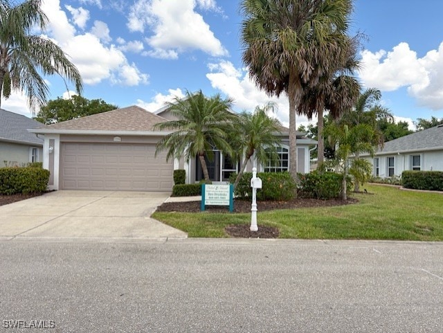 13358 Queen Palm Run, North Fort Myers, FL 33903 - view of front of property featuring a garage, a front yard, stucco siding, and concrete driveway