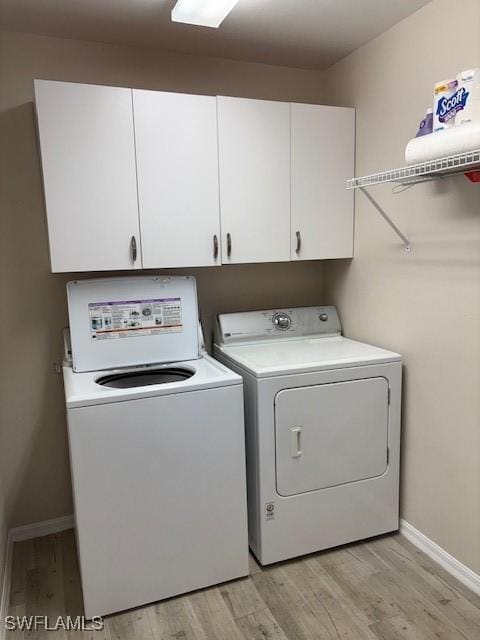 13358 Queen Palm Run, North Fort Myers, FL 33903 - washroom featuring cabinet space, washing machine and clothes dryer, light wood-type flooring, and baseboards