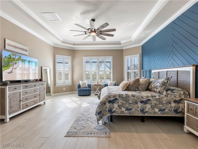 bedroom featuring a tray ceiling, ceiling fan, ornamental molding, and light wood-type flooring