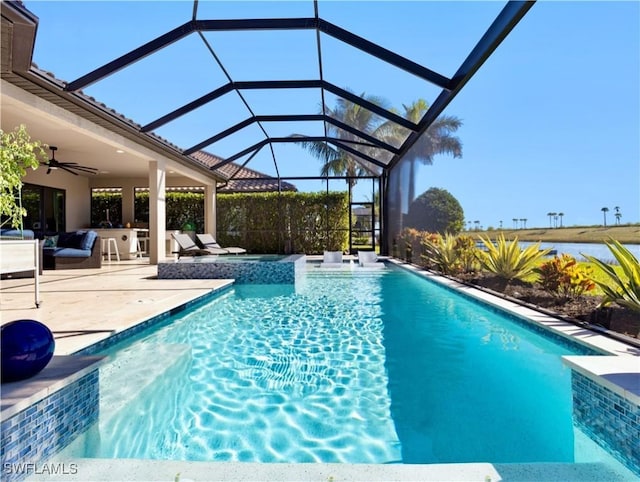 view of pool featuring glass enclosure, ceiling fan, an in ground hot tub, and a patio