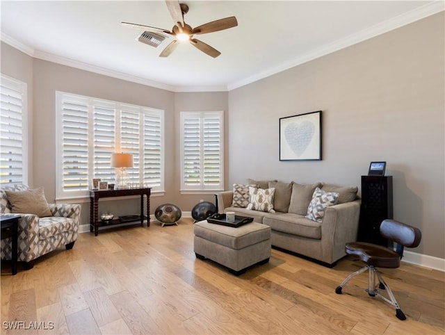 living room with ceiling fan, plenty of natural light, ornamental molding, and light wood-type flooring