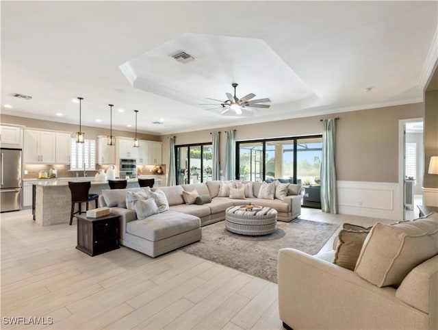 living room with light hardwood / wood-style flooring, ceiling fan, and a healthy amount of sunlight