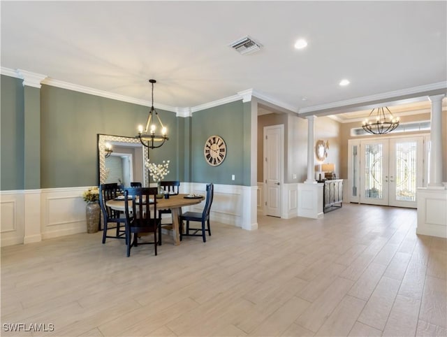 dining space featuring french doors, light hardwood / wood-style flooring, ornamental molding, and an inviting chandelier