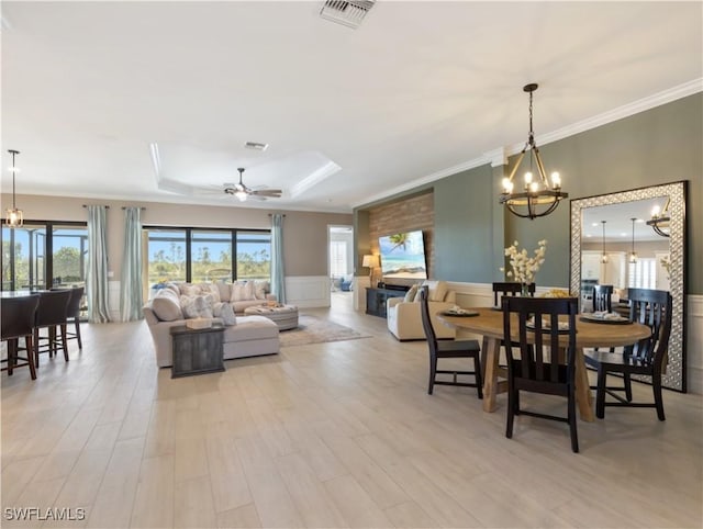 dining space featuring ceiling fan with notable chandelier, light hardwood / wood-style flooring, and ornamental molding