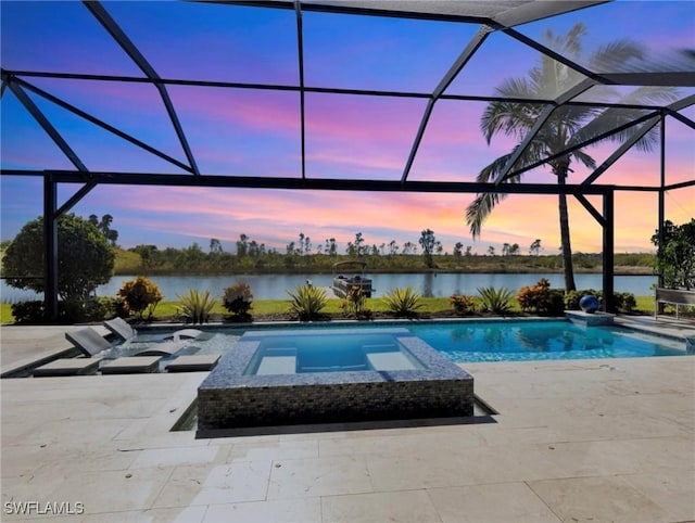 pool at dusk with an in ground hot tub, a patio, a water view, and a lanai