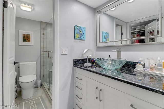 bathroom featuring vanity, an enclosed shower, and toilet