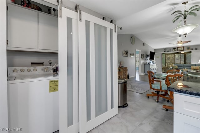 washroom featuring cabinets, washer / dryer, a barn door, and ceiling fan