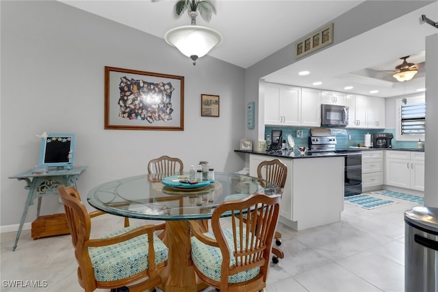 dining room featuring ceiling fan, a raised ceiling, and light tile patterned floors