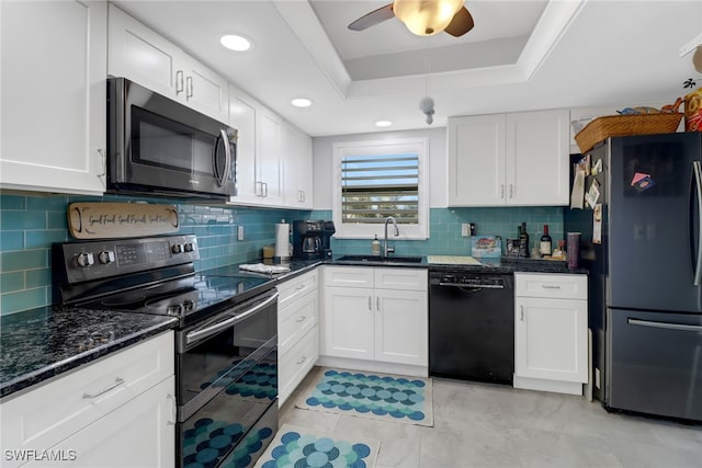 kitchen with a raised ceiling, sink, white cabinets, and black appliances