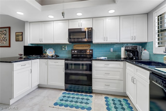 kitchen with dark stone counters, black appliances, sink, decorative backsplash, and white cabinetry