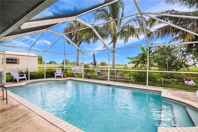 view of pool with a patio area and a lanai