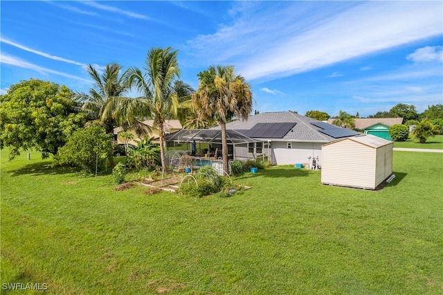 back of property with a lawn, a lanai, and solar panels