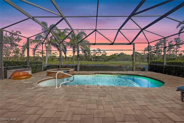 pool at dusk featuring a lanai, an in ground hot tub, and a patio