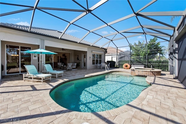 view of swimming pool with an in ground hot tub, a lanai, ceiling fan, and a patio area