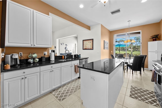 kitchen with decorative light fixtures, white cabinetry, sink, and light tile patterned floors