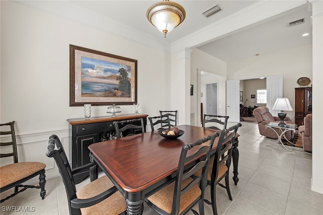 dining room featuring crown molding, ornate columns, and light tile patterned flooring