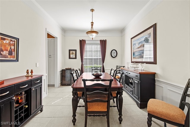 dining space featuring ornamental molding and light tile patterned flooring