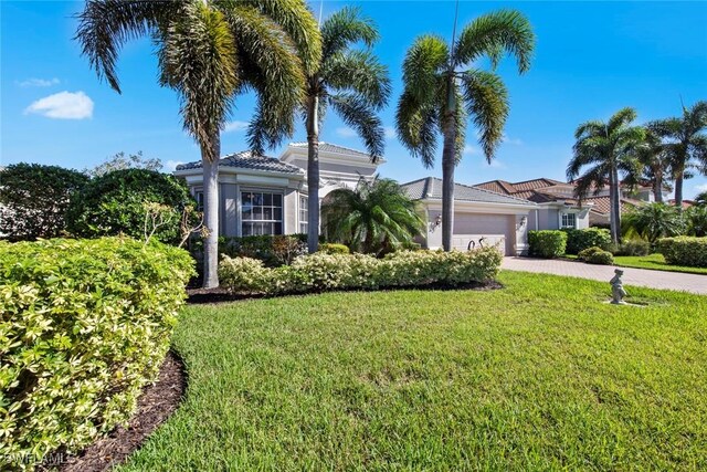 mediterranean / spanish-style house with a garage and a front yard