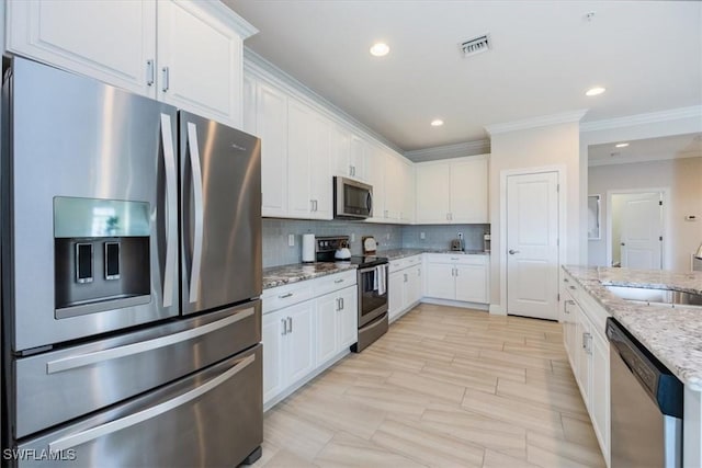 kitchen featuring white cabinets, stainless steel appliances, light stone counters, and tasteful backsplash