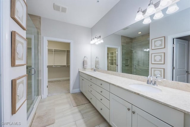 bathroom featuring tile patterned floors, vanity, and a shower with shower door