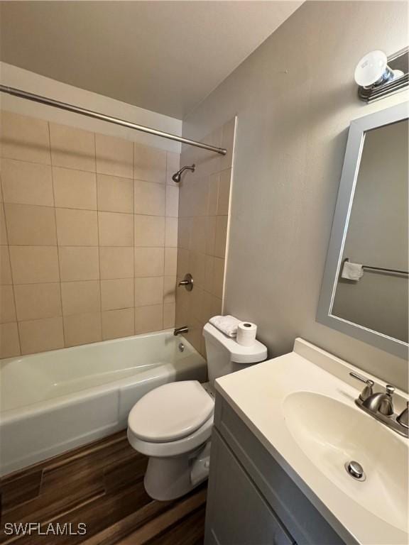 full bathroom featuring vanity, toilet, tiled shower / bath, and hardwood / wood-style flooring