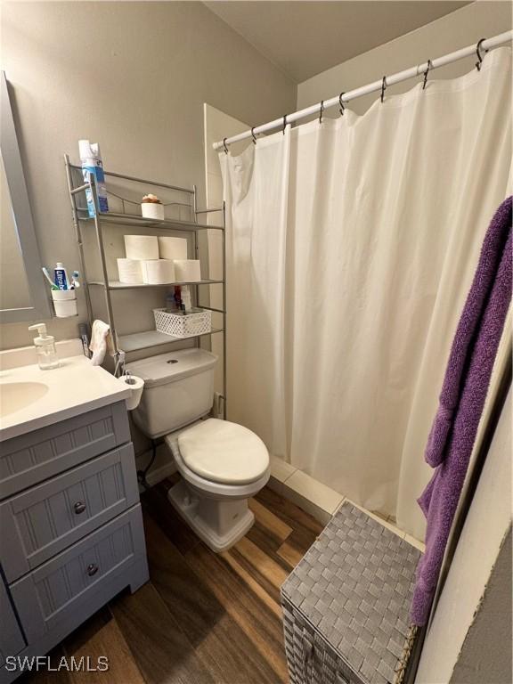 bathroom with hardwood / wood-style floors, vanity, and toilet