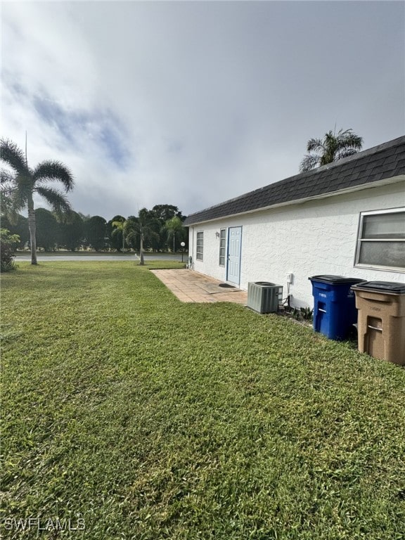 view of yard featuring a patio area and central air condition unit