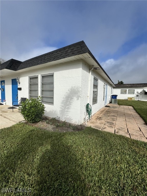 view of property exterior with a lawn and a patio