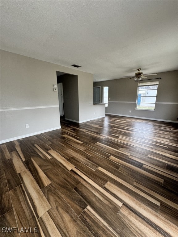 unfurnished room with a textured ceiling, dark hardwood / wood-style flooring, and ceiling fan